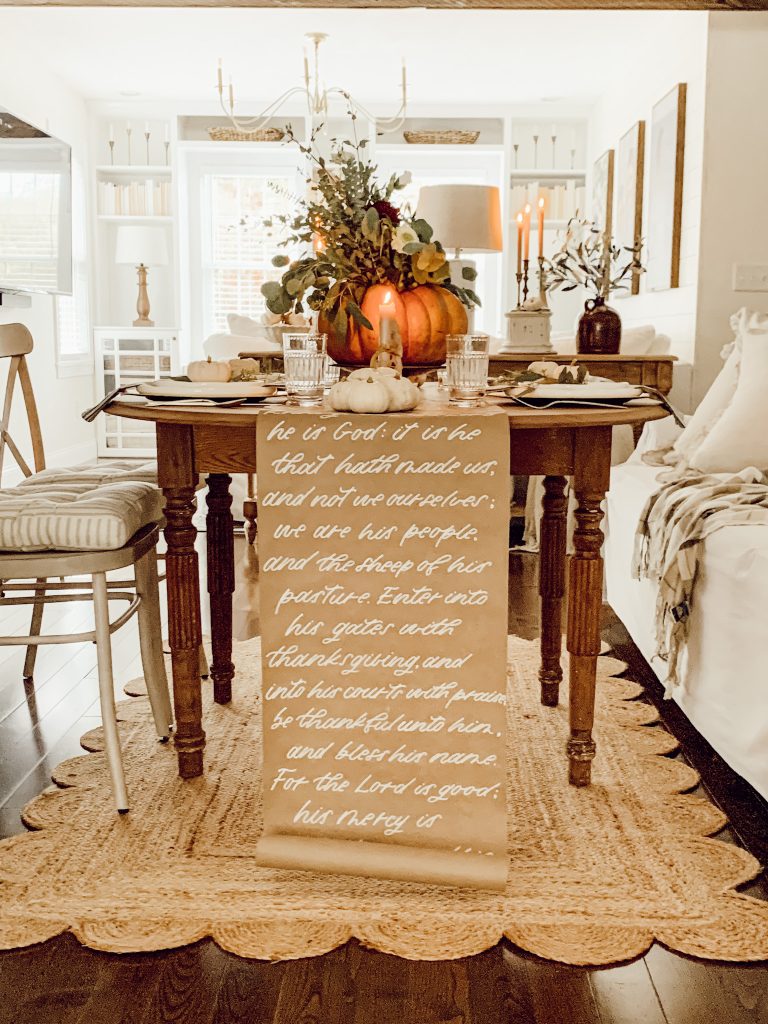 Thanksgiving table in dining room with a pumpkin centerpiece and vintage accents from thrift stores.