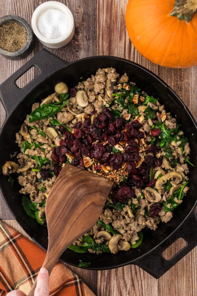 Mix in dried cranberries and chopped pecans into the sausage filling for the pumpkins.