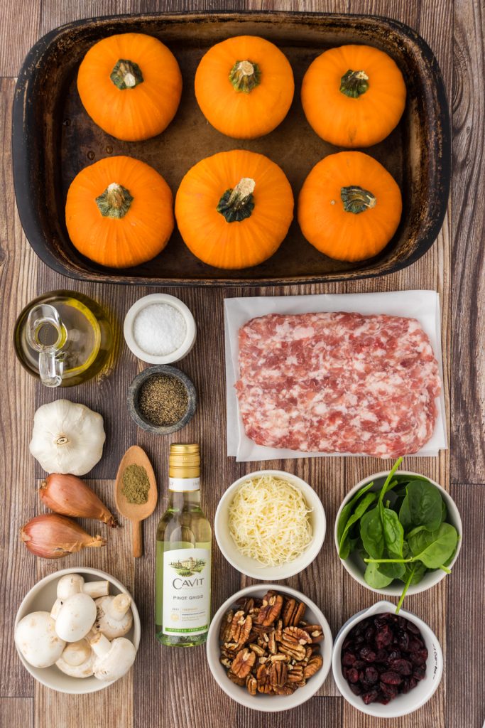 Small orange pumpkins, Italian sausage, fresh sage, pecans, dried cranberries, shallots, mushrooms, and seasonings for stuffed pumpkins.