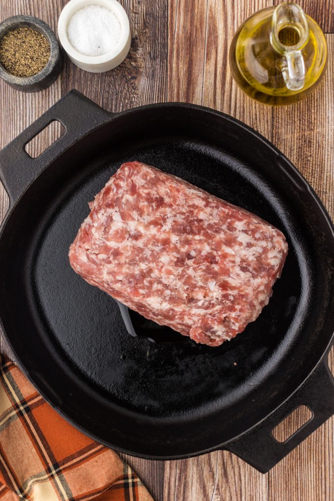 Italian sausage in a large cast iron skillet to make sausage stuffing for pumpkins.