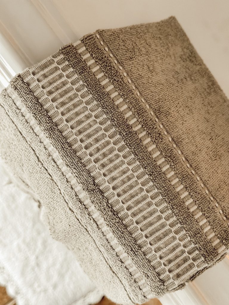Green hand towel on bathroom sink for simple Christmas decorations in the powder room.