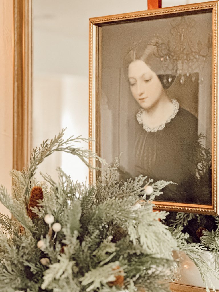Vintage artwork hanging with wide ribbon in the living room for the holiday season.