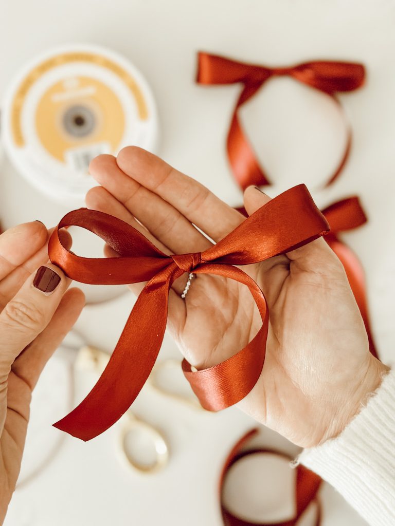 A Christmas bow with red Christmas ribbon to attach to the DIY tree.