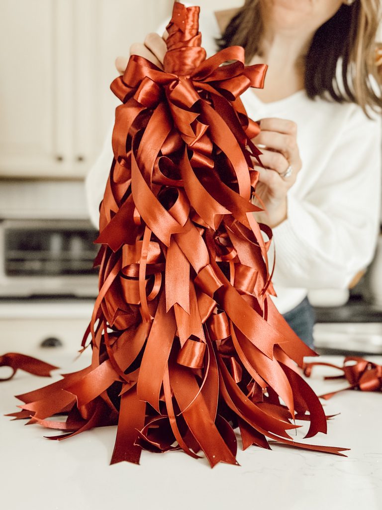 DIY Christmas tree made entirely of satin ribbon tied into small bows.