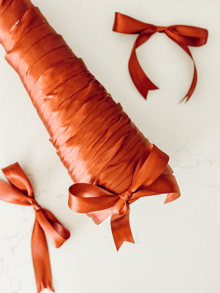 A satin bow pinned to the bottom of the handmade Christmas tree.