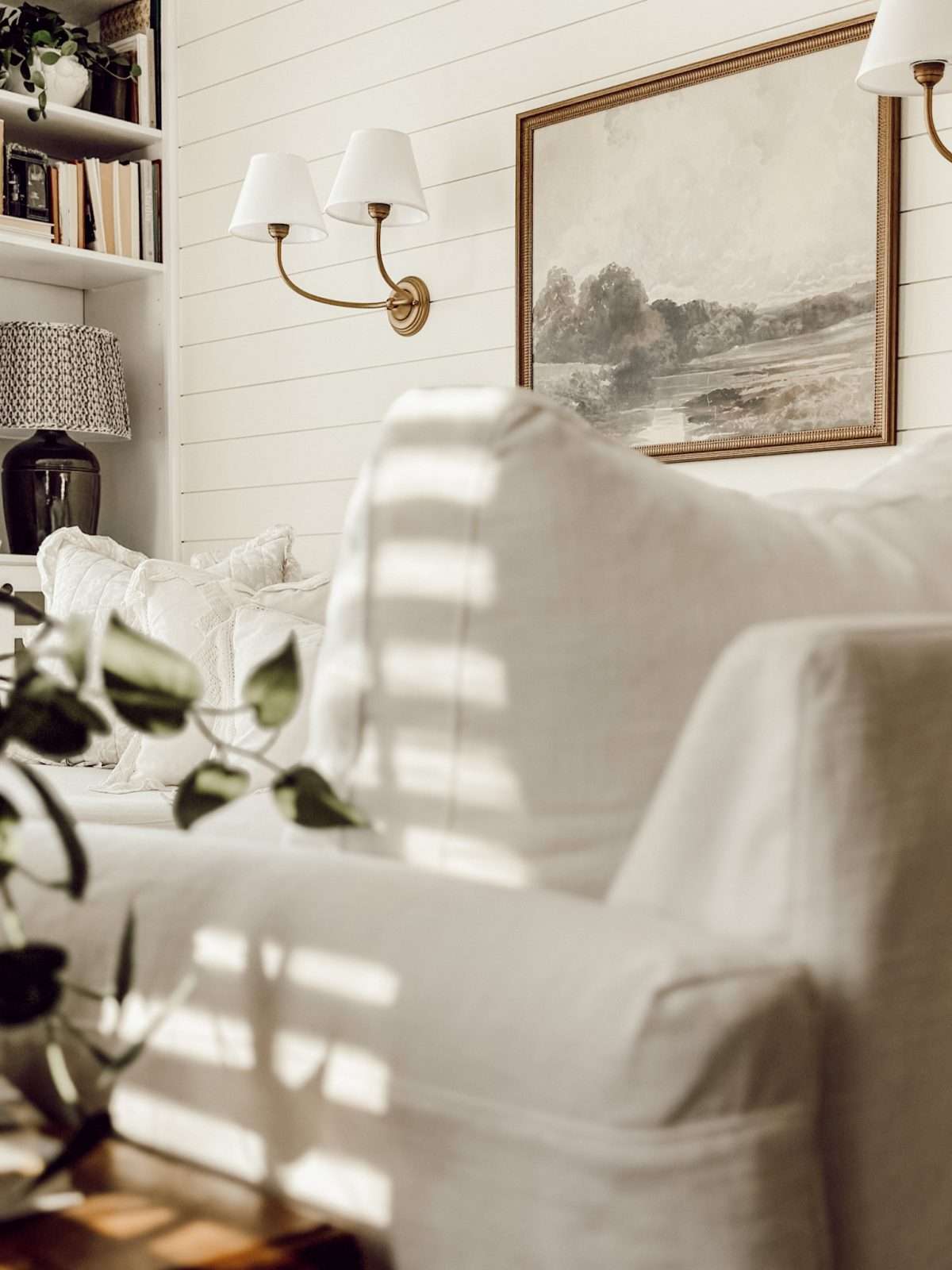 Shaded light sconce hanging on living room wall for cozy ambient lighting.