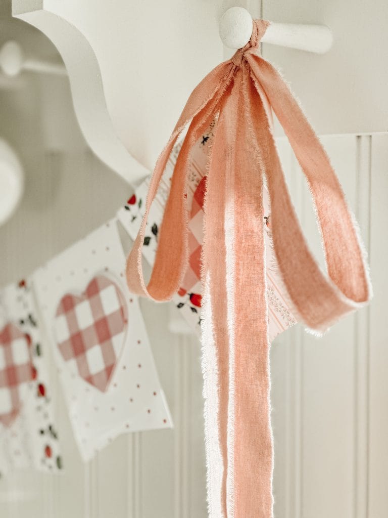 Pink frayed edge ribbon tied onto Valentine garland for a touch of love.