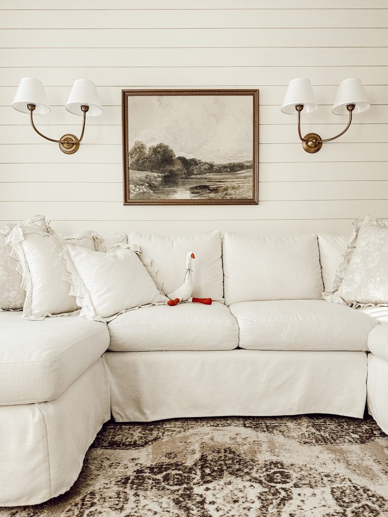 Sconce lights with shades mounted to a shiplap wall for extra coziness.