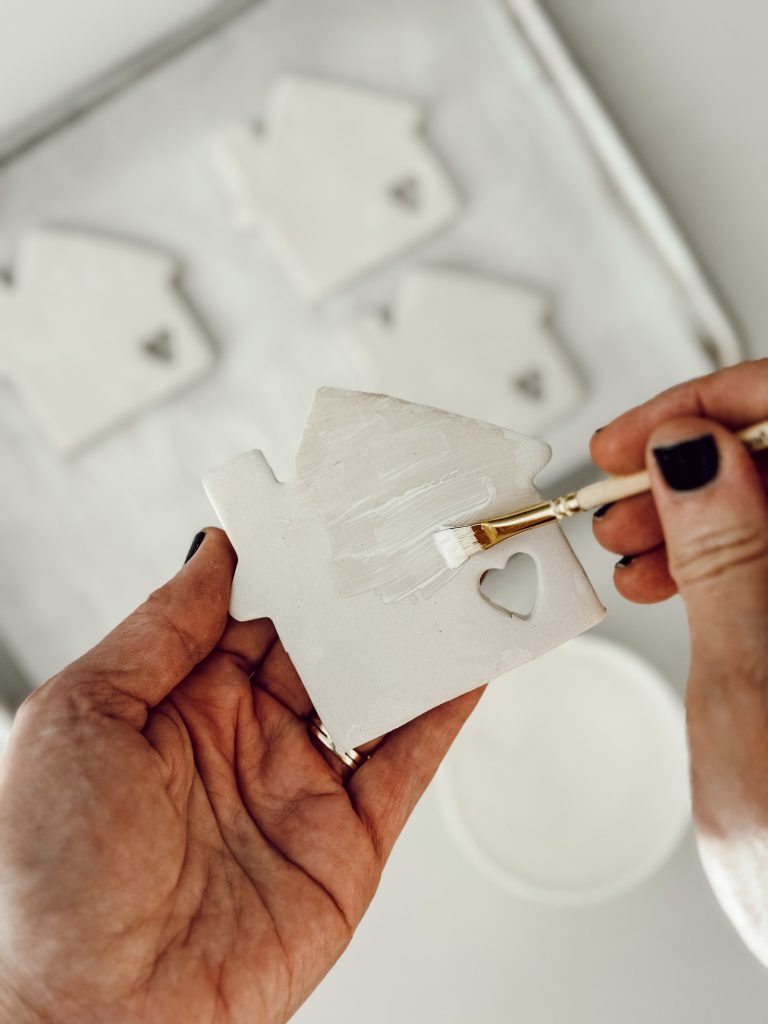 Use a small paintbrush to apply waterproof sealant to the DIY coasters. 