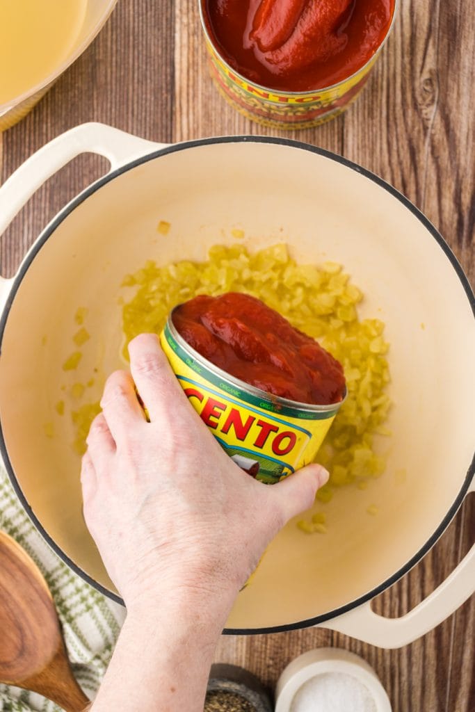 Pour a can of Cento canned San Marzano tomatoes into dutch oven.