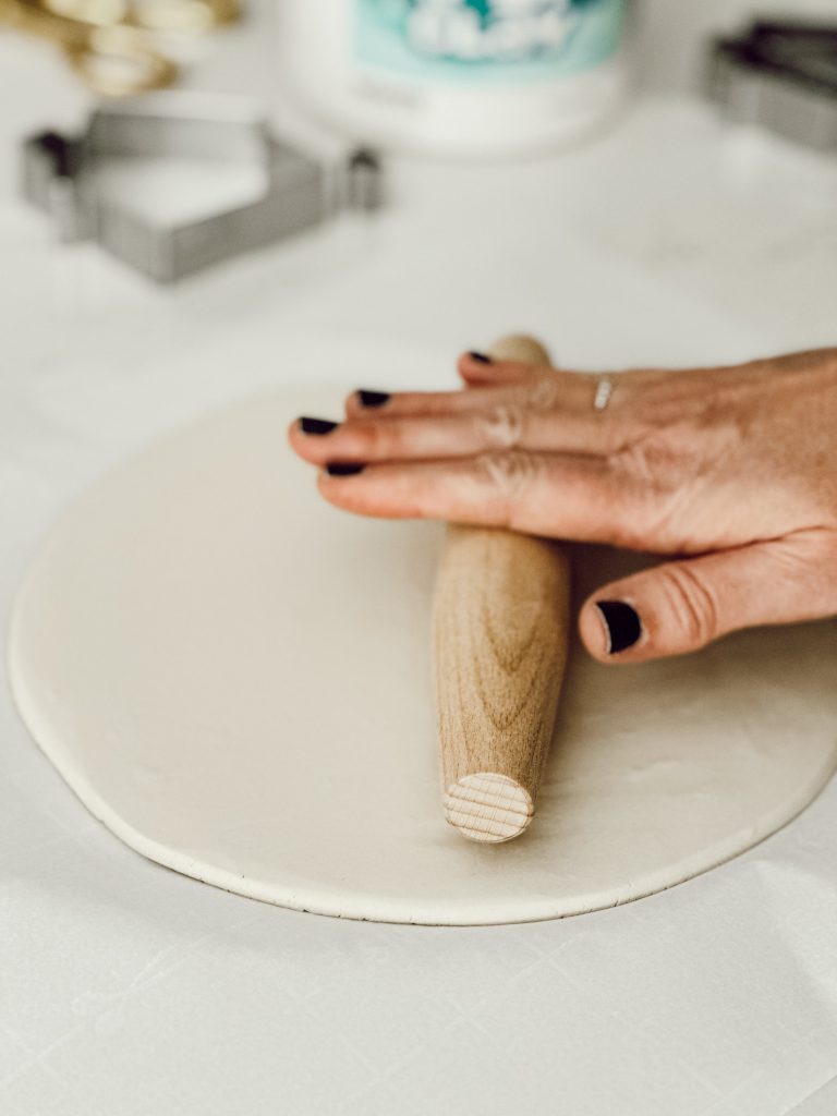 Use a wooden rolling pin to roll out white clay into a flat surface.