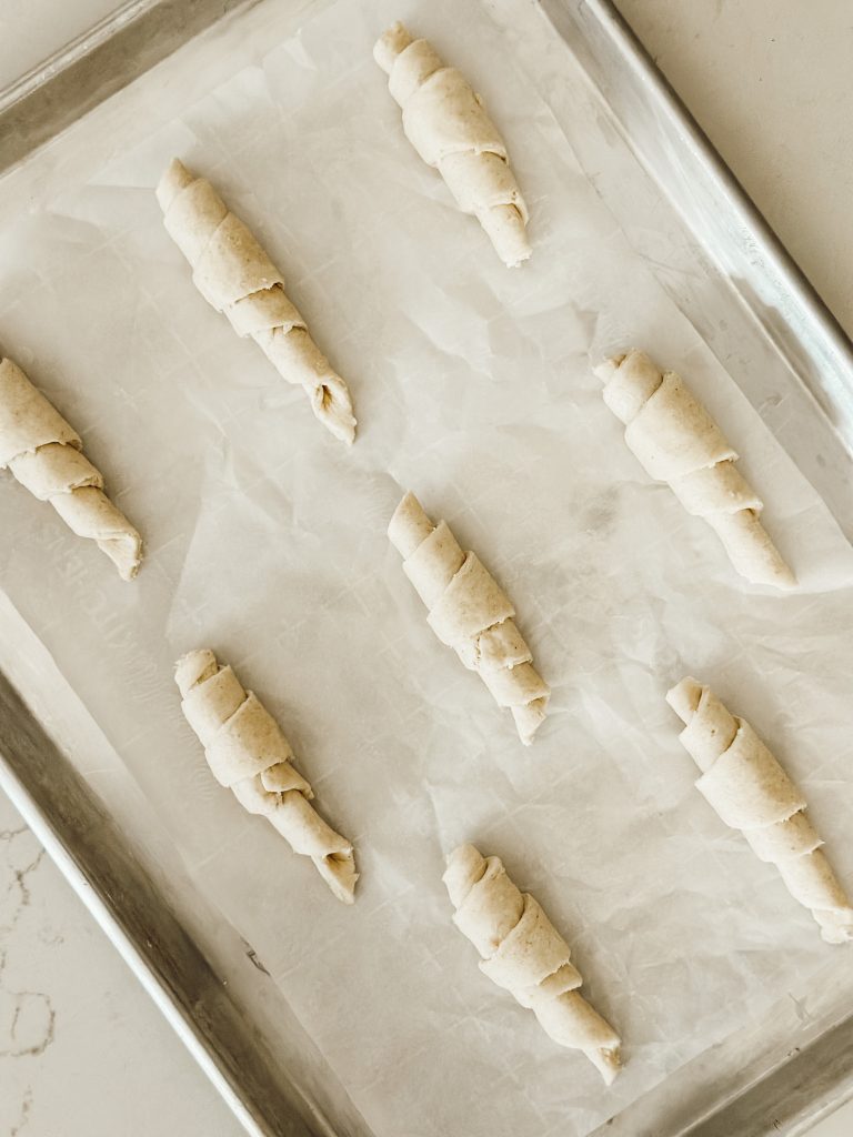 Place the unbaked crescent rolls on a parchment paper lined cookie sheet for baking in the oven.