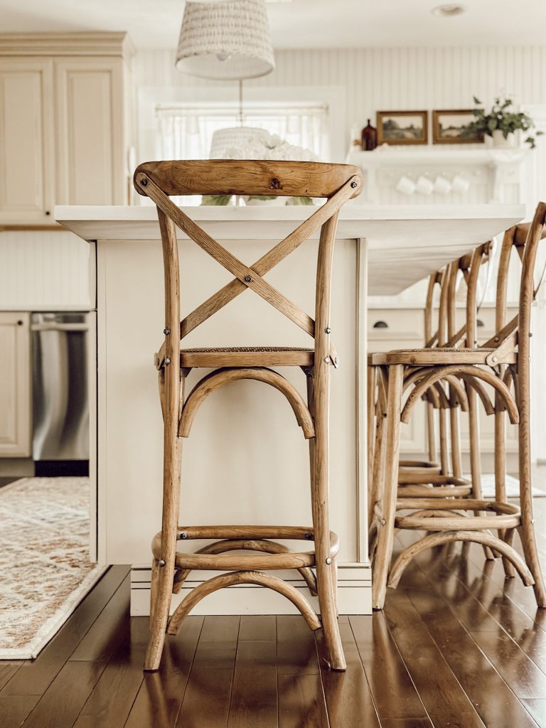 Four wooden cross back counter stools at the kitchen island.