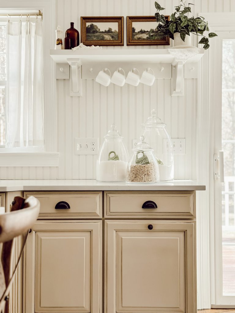 A great way to add a cozy cottage feel to the kitchen is with an open shelf styled with seasonal decor.
