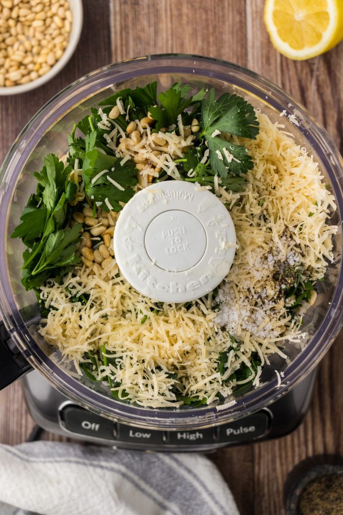 All of the pesto ingredients added to the food processor for blending.