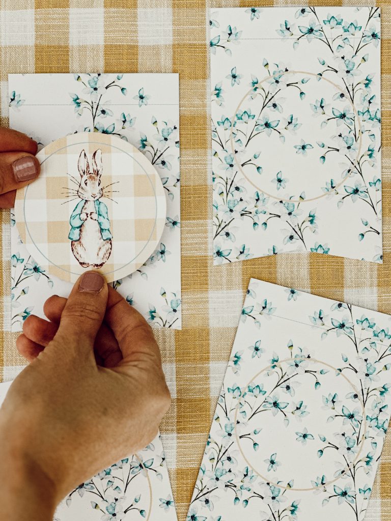 Press the Peter Rabbit circular embellishment to the paper pennant using the foam sticker.