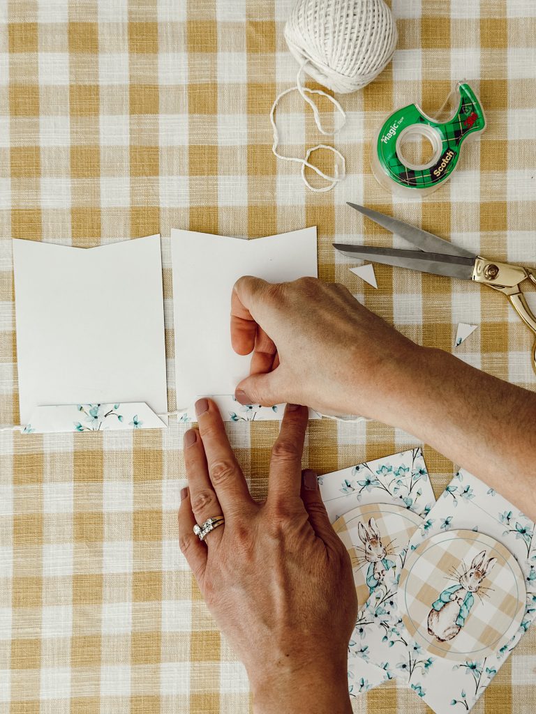 Use a piece of Scotch tape to attach the top of the pennant to the kitchen twine.