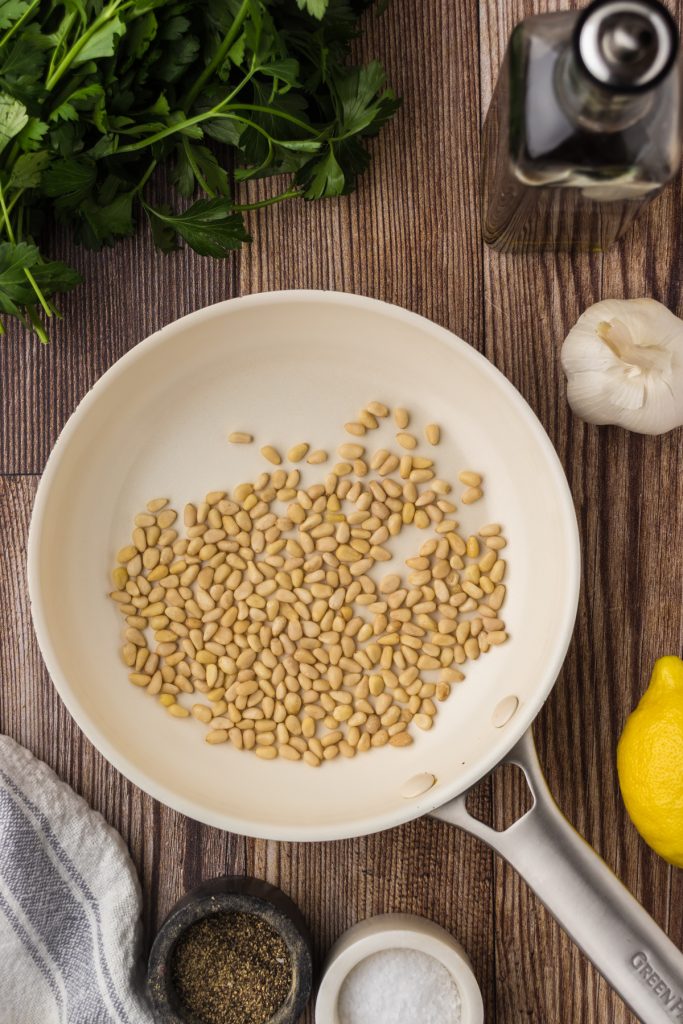 Toasting pine nuts on medium-low heat in a small saucepan.