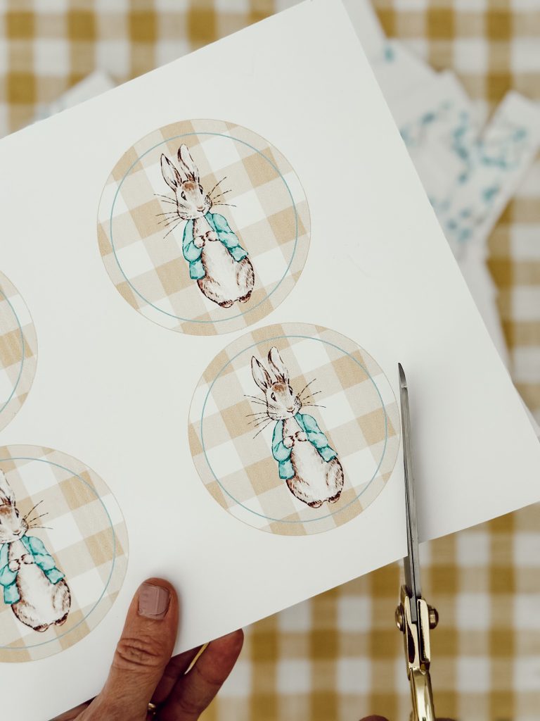 Sharp scissors cutting out the circular Peter Rabbit shapes to attach to the pennants.