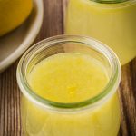 Mason jars with fresh homemade lemon concentrate on a wooden kitchen counter.