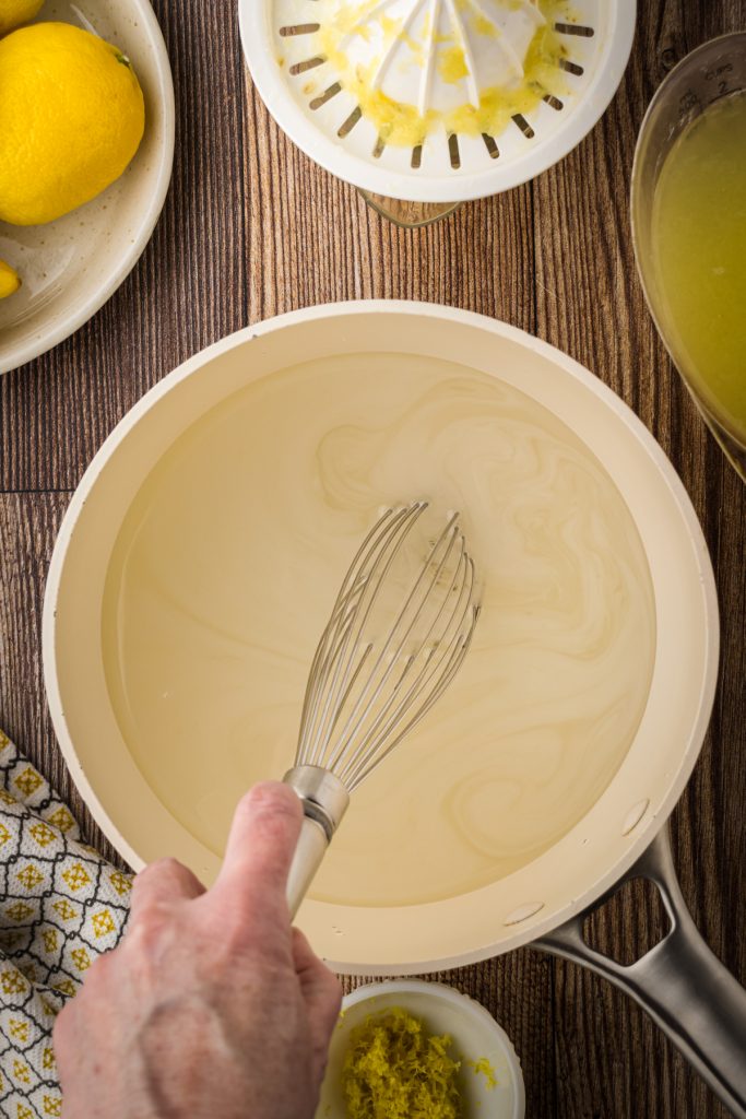 Whisking the simple syrup in a medium saucepan to dissolve white sugar into water.