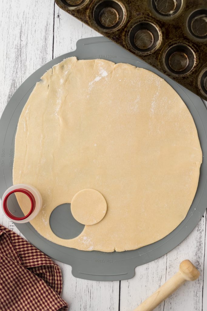 Using a small circle cutter, cut out circle shapes from the pie dough to add to the mini muffin pan.
