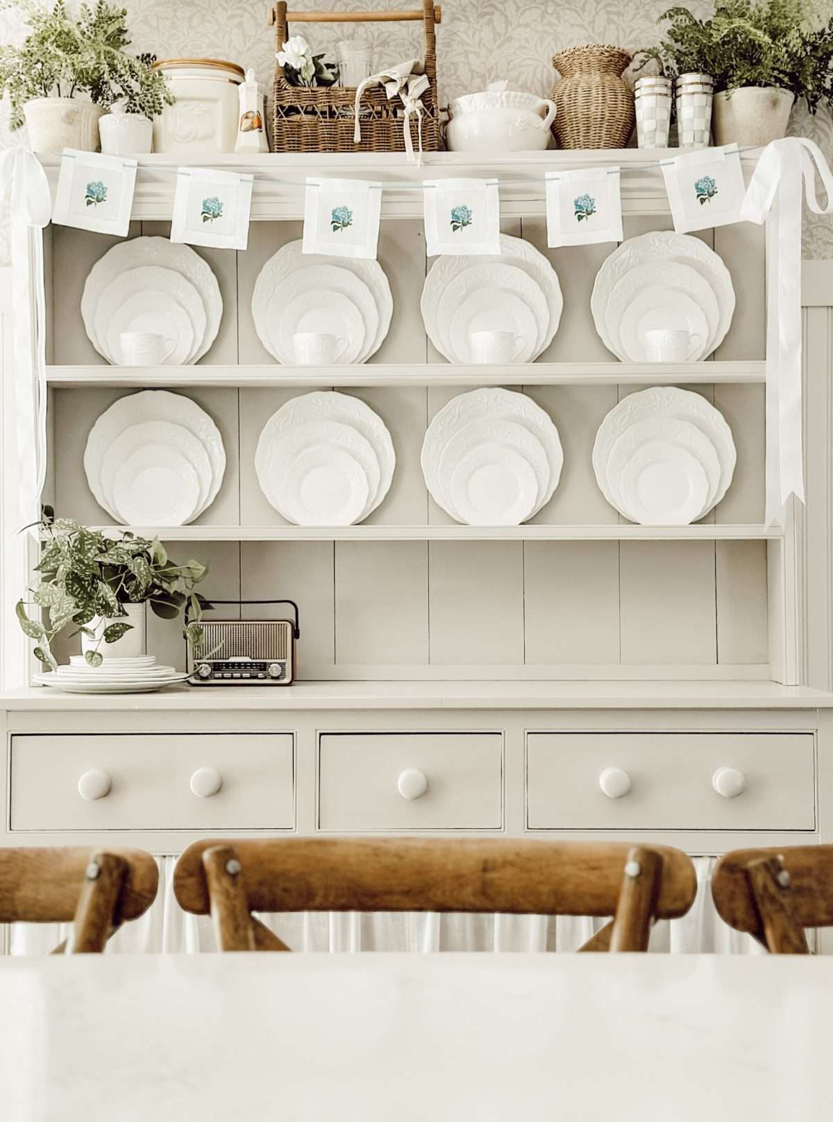 DIY garland using fabric coasters hanging on hutch in the kitchen for simple home decor.