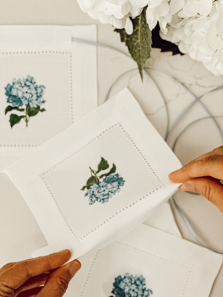 Folding the top of the fabric coasters to find where to cut the slit for threading the ribbon through.