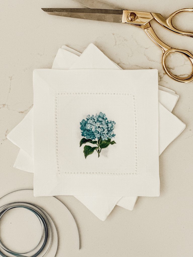 Supplies you'll need to make a DIY fabric garland include fabric coasters, satin ribbon, and scissors.