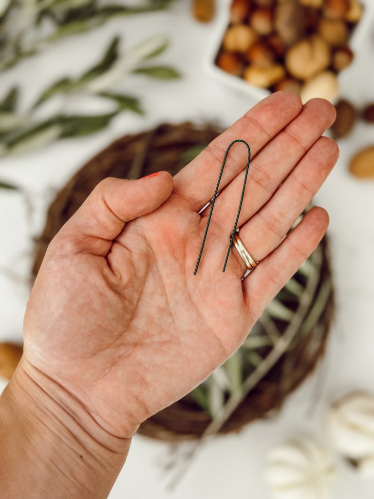 Green floral wire that is used to attach the olive branches to the wreath base to keep them securely in place.