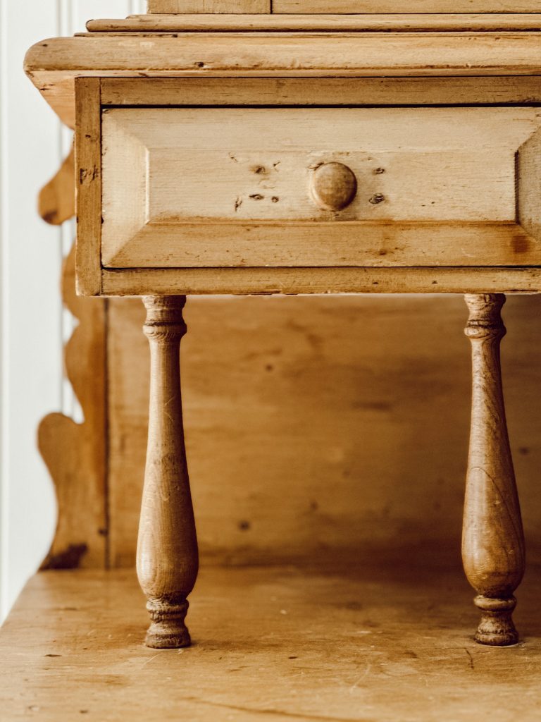 Some of the original details of our scrubbed pine hutch include wooden handles, scalloped details, and wooden pegs.