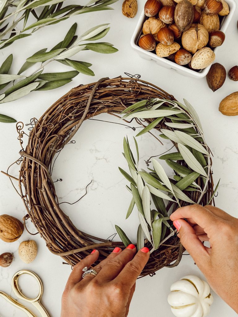 Using the florist wire to attach the fresh stem to the candle ring base.