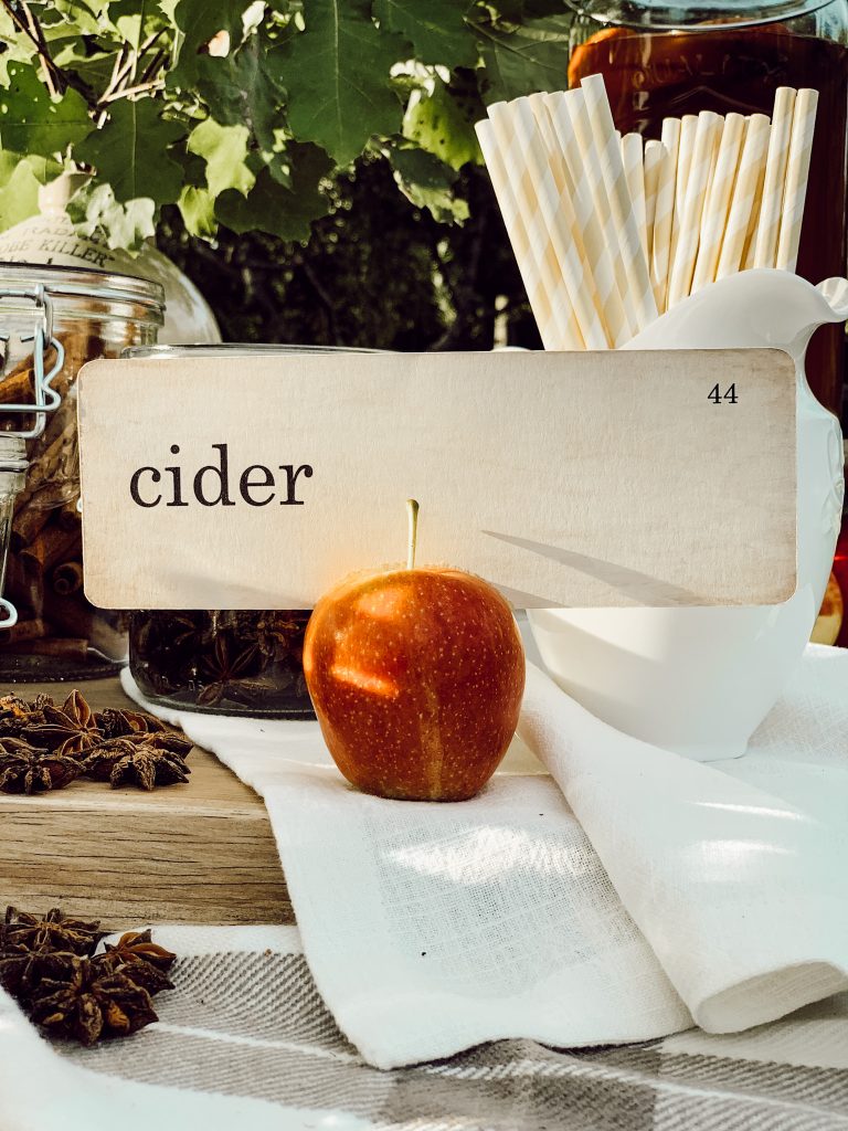 Cider drink station for autumn entertaining with fresh apples and spices to make homemade apple cider drinks.
