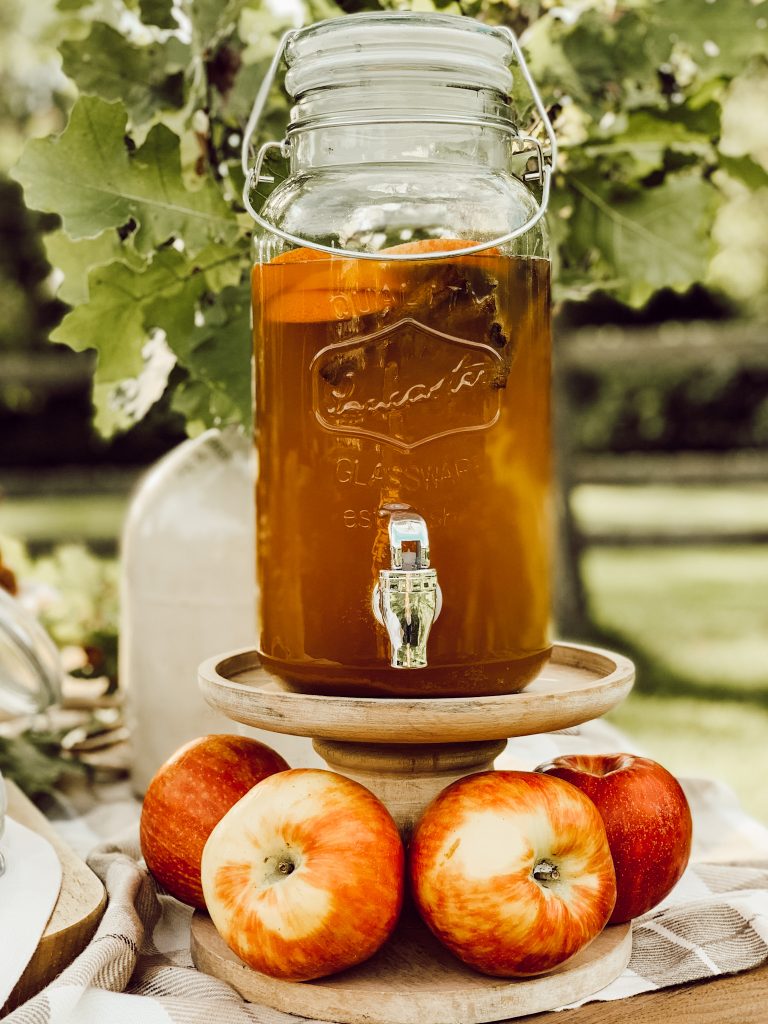 A mason jar drink dispenser to hold cold apple cider for an apple cider station.