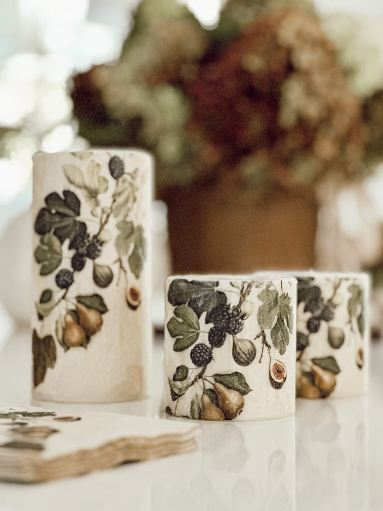DIY botanical printed candles on kitchen countertop with a basket of fresh hydrangeas.