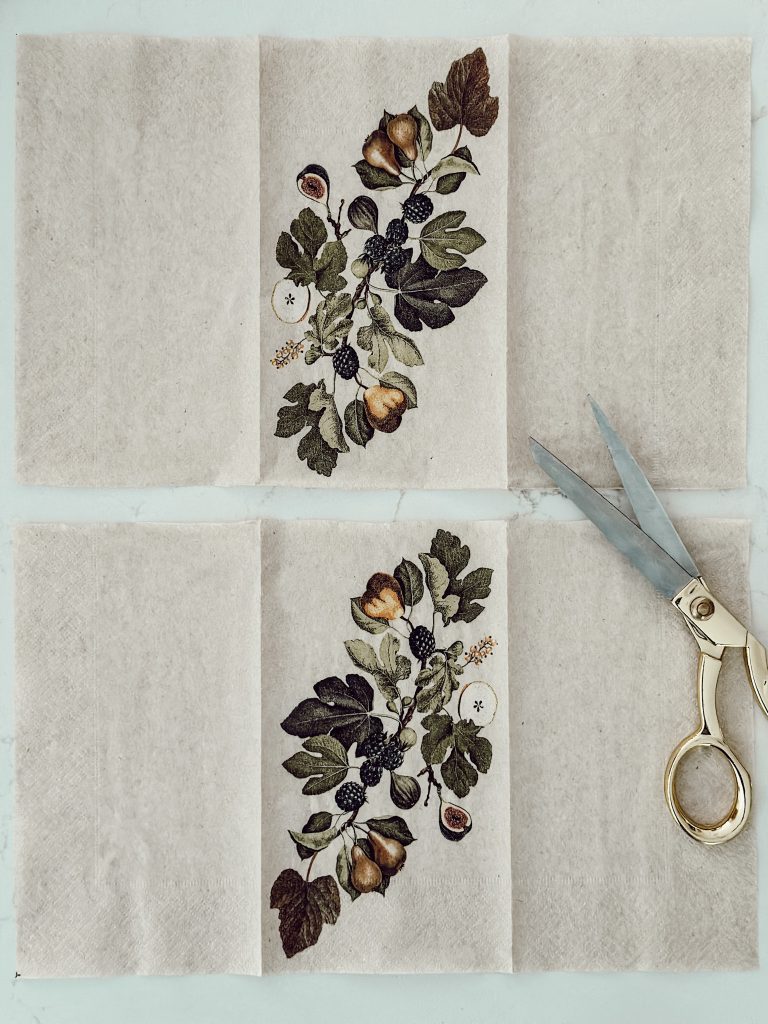 The top piece of the paper napkin cut into two sections to cover pillar candles.