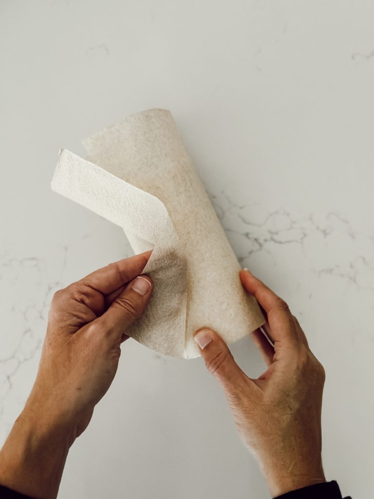 Trim off the excess paper napkin to adhere the napkin to the candle properly.