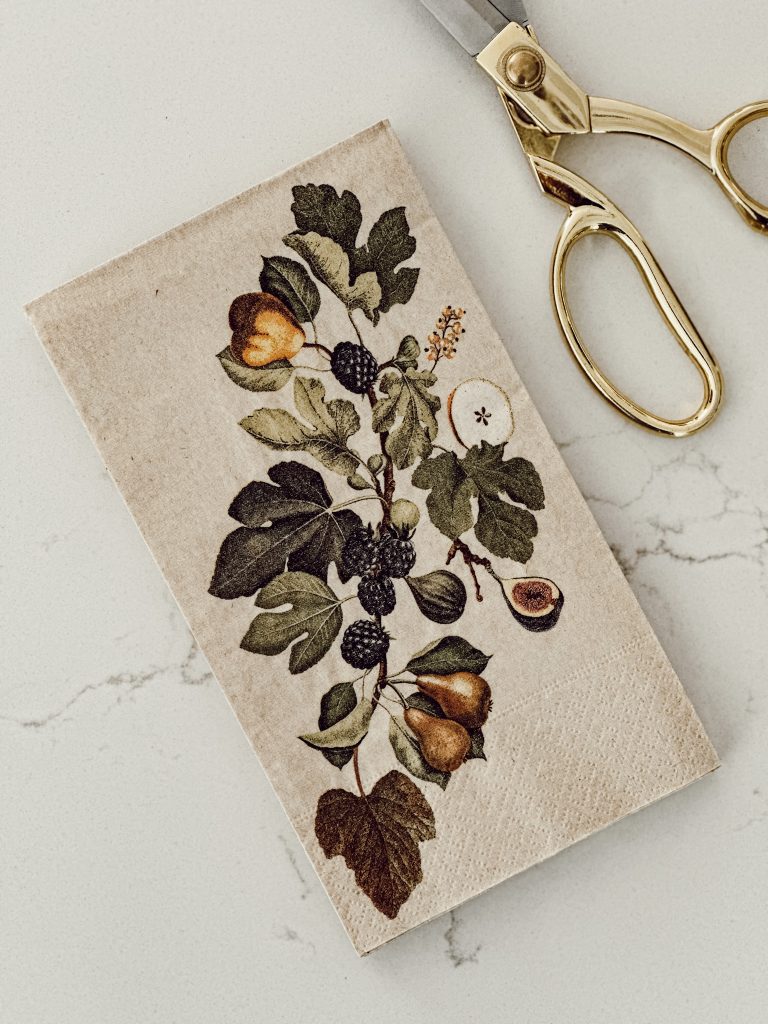 Botanical paper napkins and scissors to make DIY custom candles.