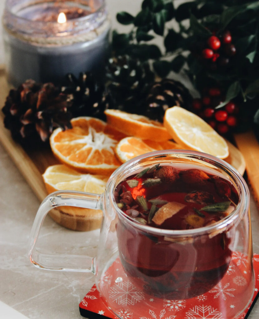 Christmas decorations for the holiday season include dried orange slices, pine cones, candle, and greenery.