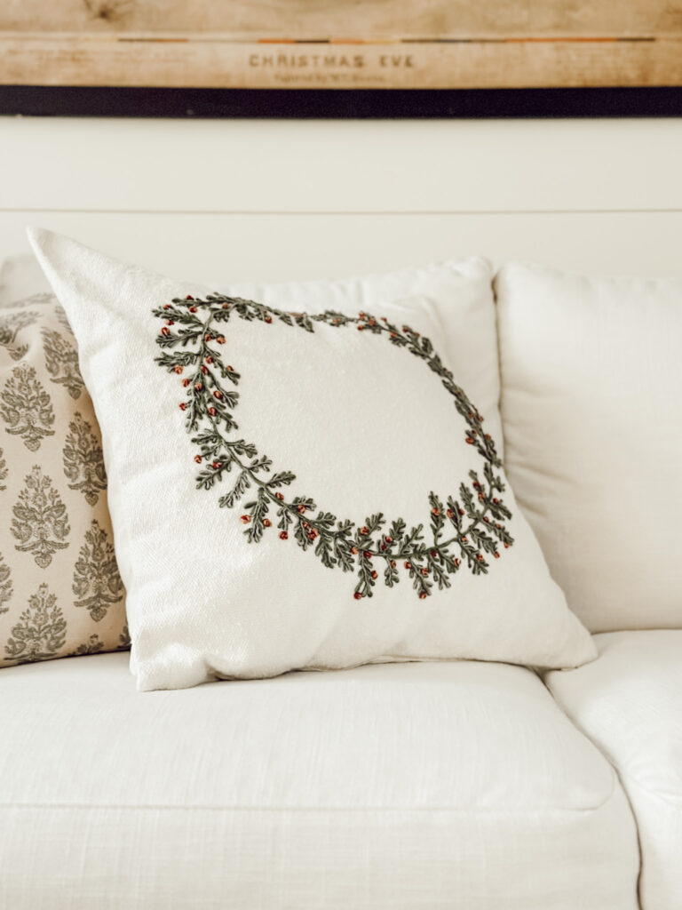 Christmas throw pillow on white couch to easily begin transitioning your home from fall to Christmas decor.