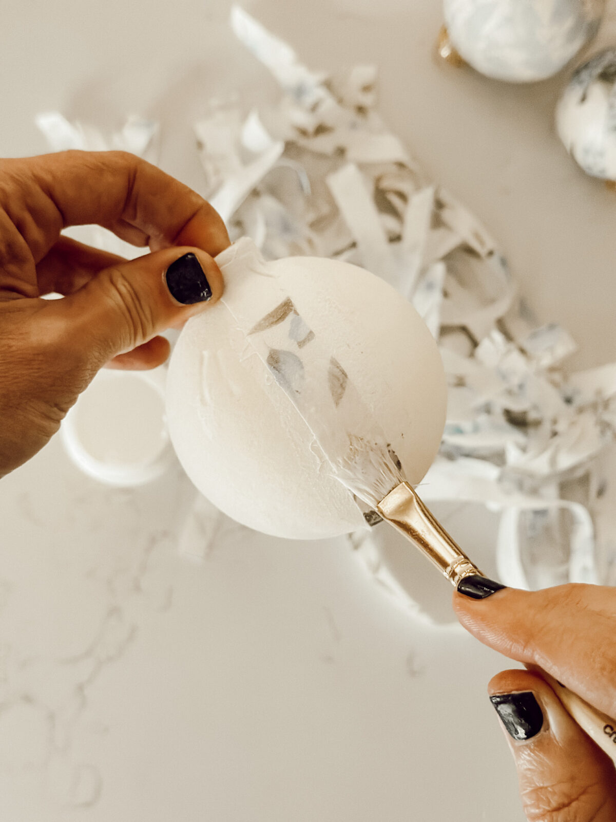 Adding a strip of fabric to the glass ornament and attaching with more Mod Podge.