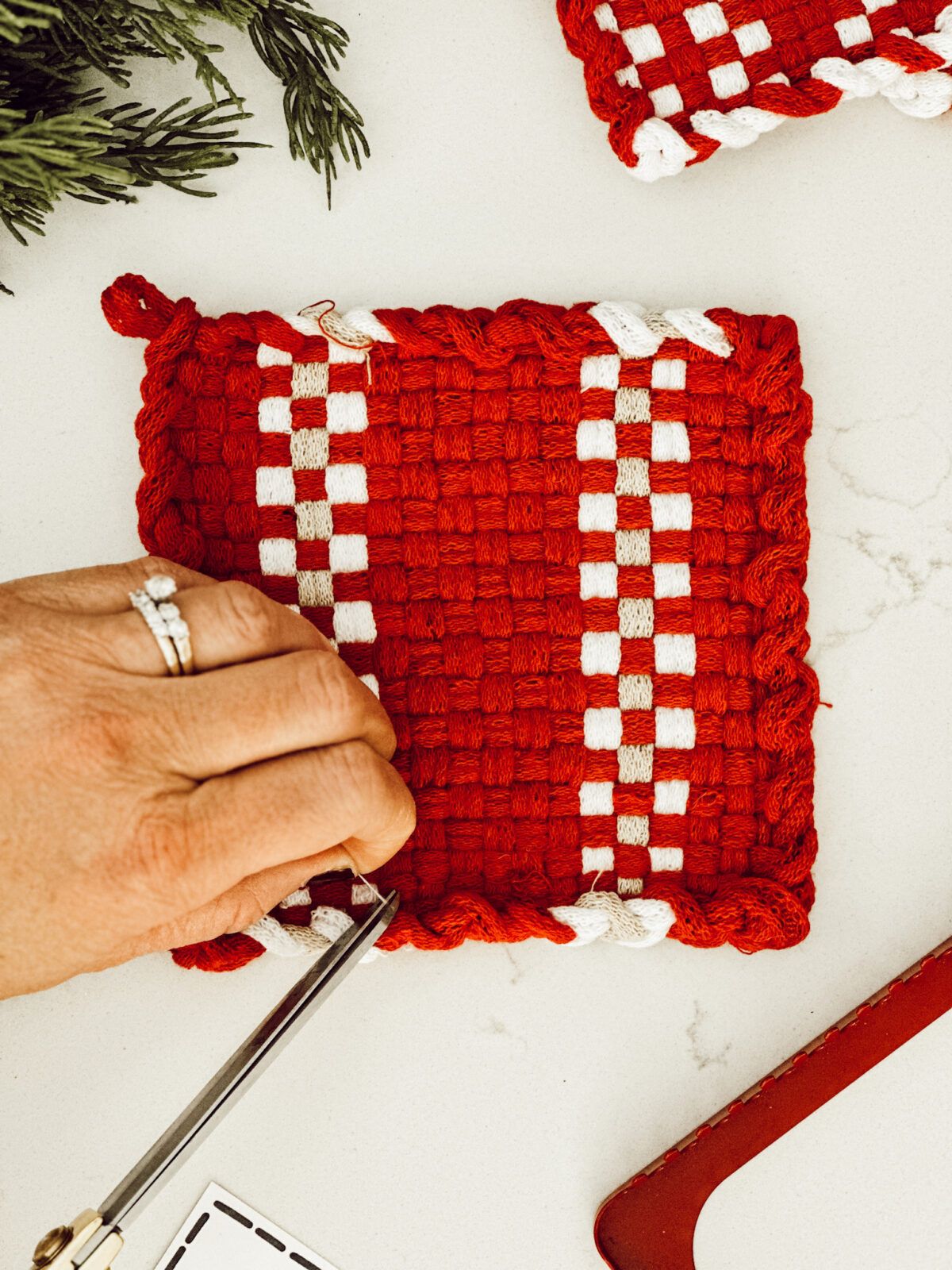 Trimming the strings from the pot holder for a neat, finished look.