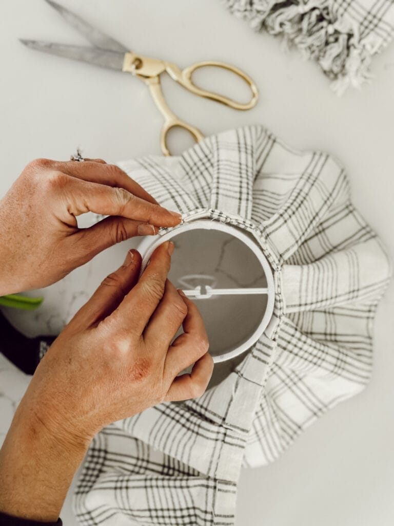 Use hot glue to attach the cover to the lamp shade for your light.