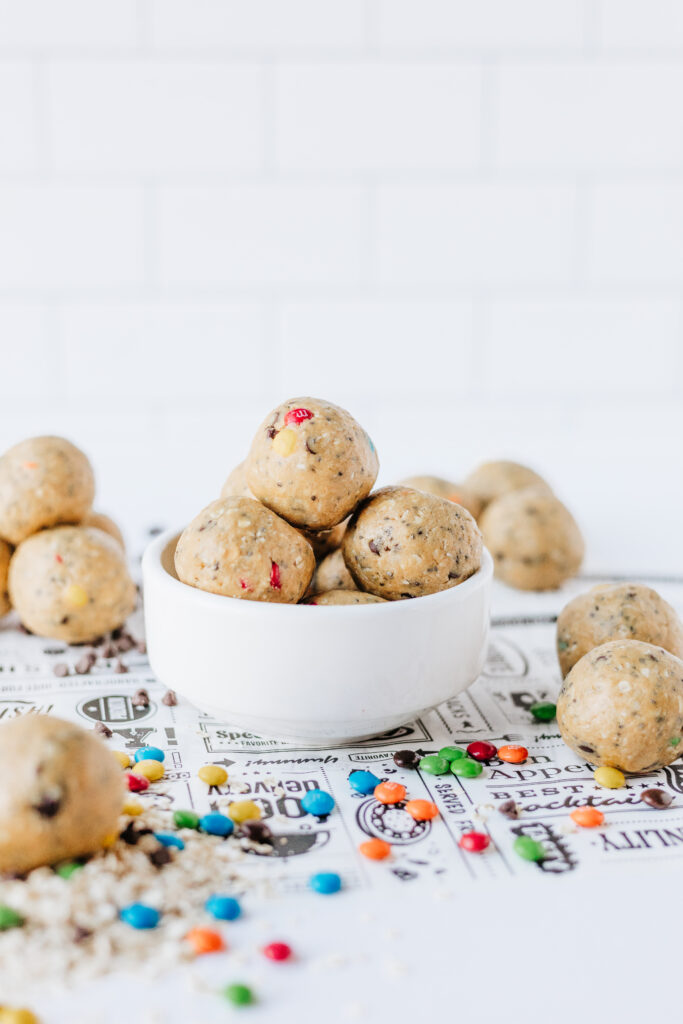 Bowl of homemade cookie flavored energy balls with mini candies for sweetness.