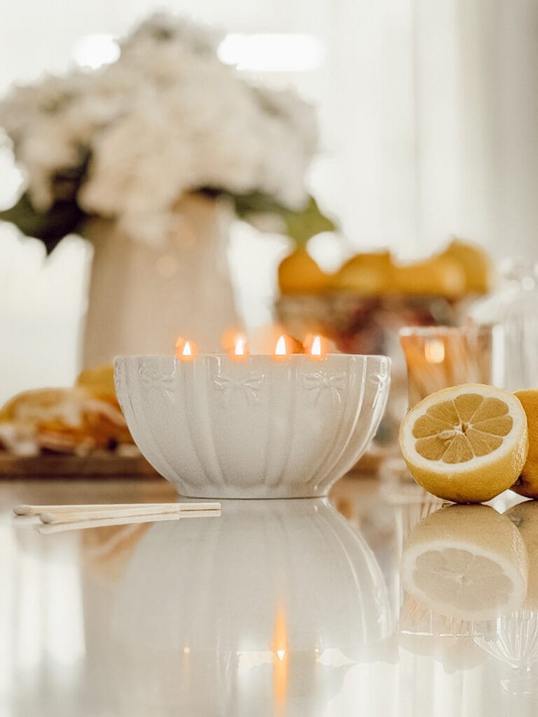 Creating a cozy home using your five senses incudes a lit candle on the kitchen counter to make your home smell good.