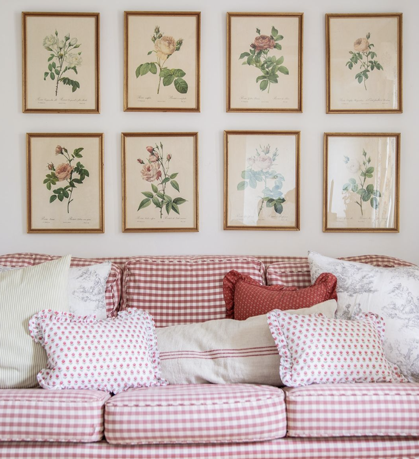 Red gingham sofa in family room with a gallery wall of framed botanical prints.