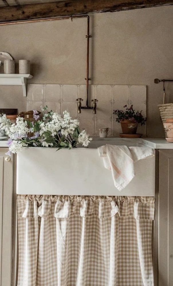 Kitchen sink skirt in a checked pattern in a cozy cottage cooking space.