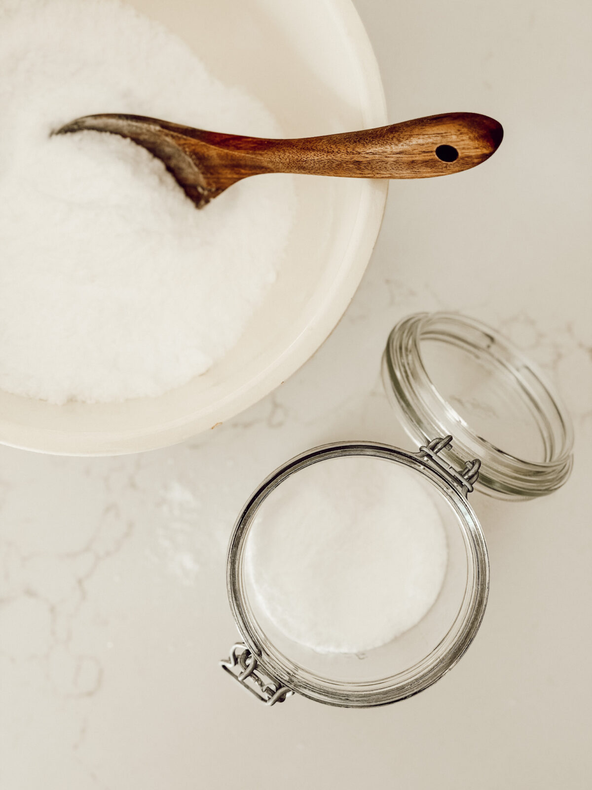 Transfer the DIY natural laundry scent booster from the mixing bowl to a glass jar for storage.