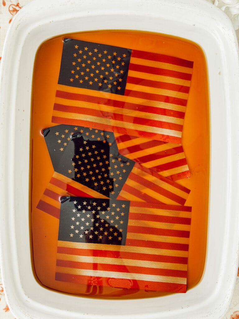 American flags soaking in a coffee bath in a baking dish.