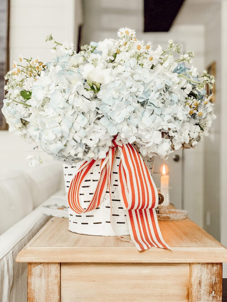 A bucket of hydrangeas and chamomile for seasonal summer decor in the family room.